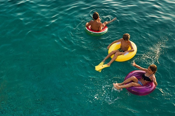 Children enjoying the water floating on inflatable rings